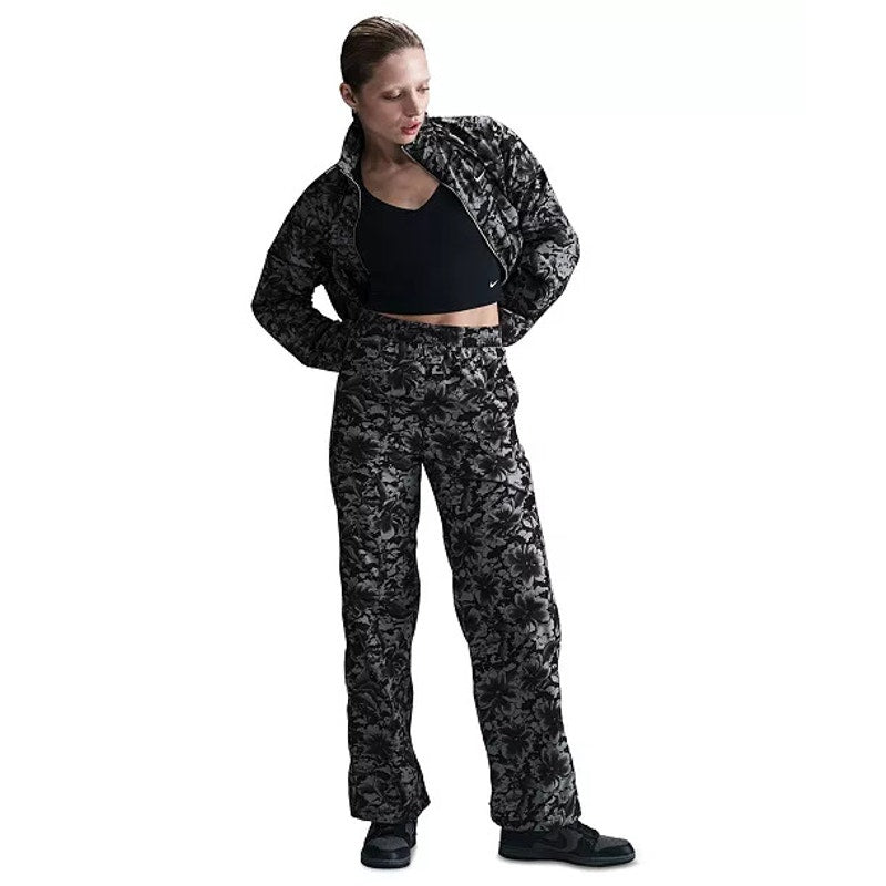 Nike Sportswear women's floral wide-leg track pants in black and gray, featuring a relaxed fit and stylish floral pattern.