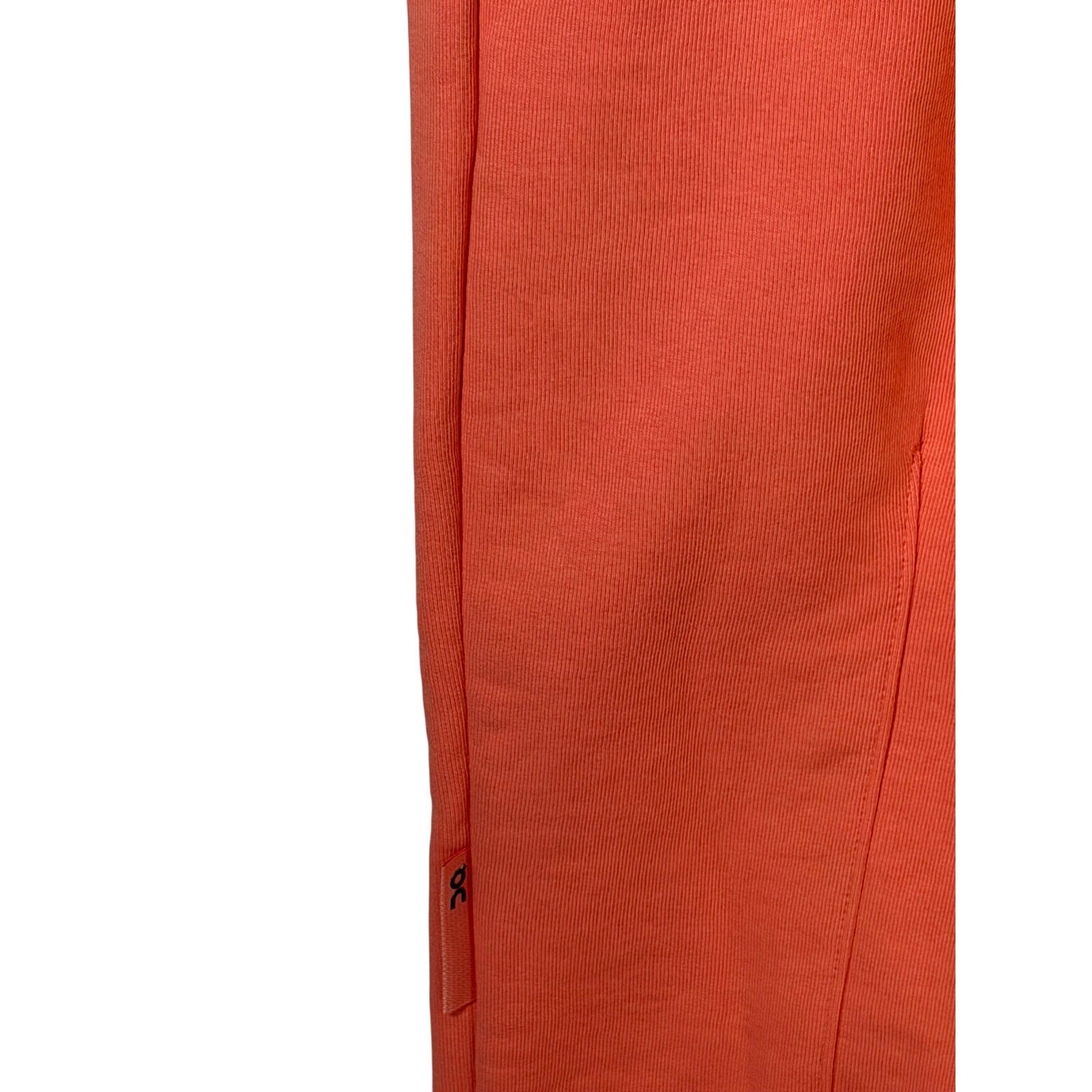 On Running women's coral orange ribbed jogger sweatpants in size XL, showing the relaxed fit and textured fabric.