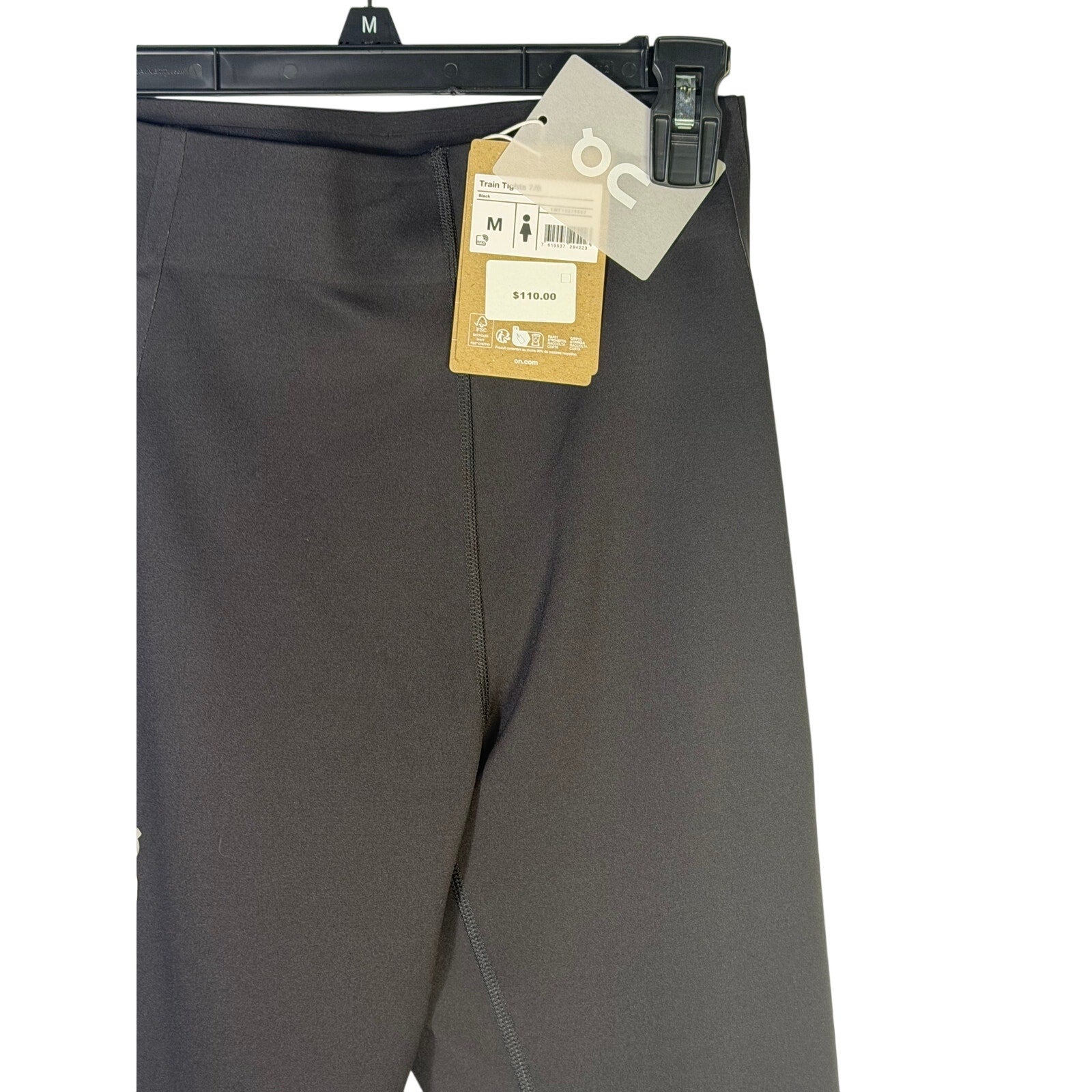 On women’s black Train Tights 7/8 leggings, size M, new with tags, shown on a model in a fitness setting.