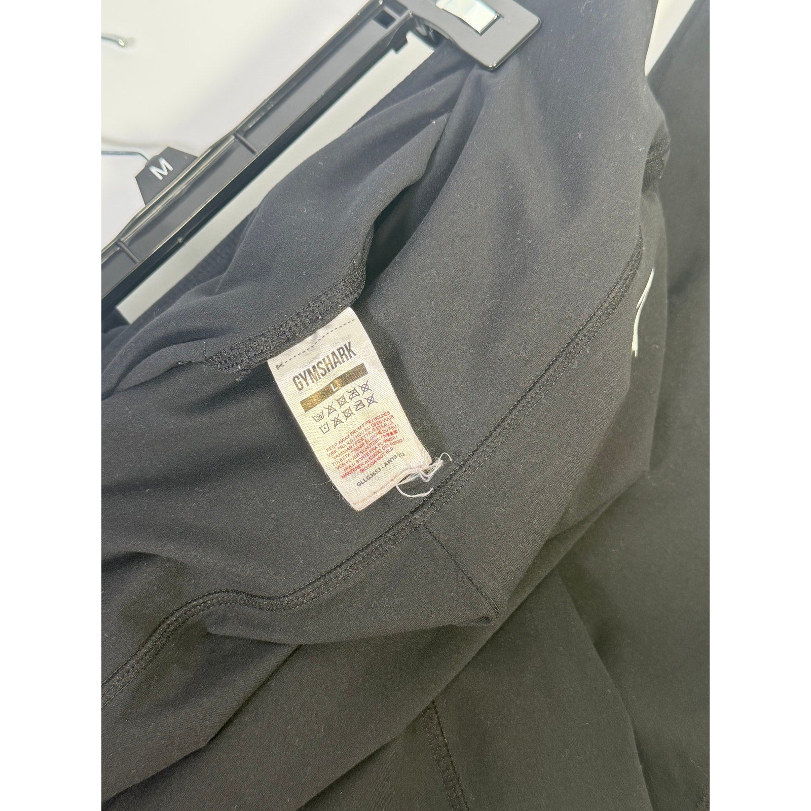 Black Gymshark women's high-waisted side pocket leggings, size large, shown on a model with a close-up view of the fabric and pockets.